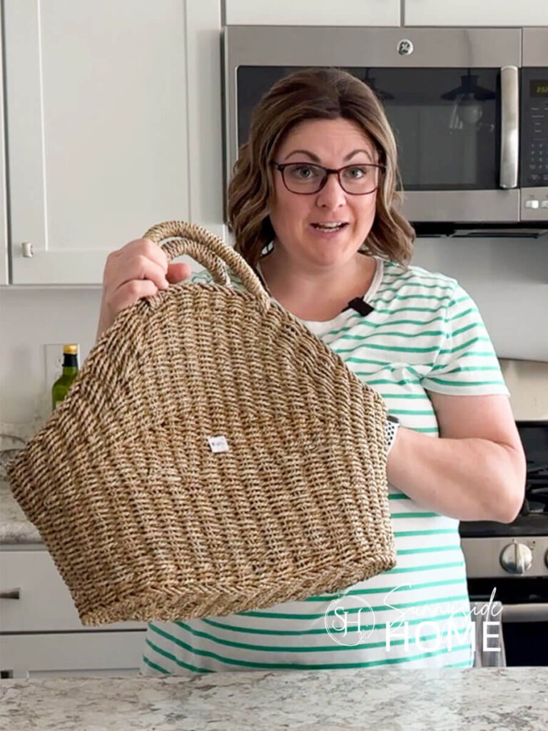 Woman holds a thrifted basket with handles.