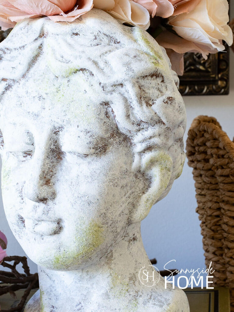 Textured head vase with layers of paint created an old world finish styled with florals on a book stack.
