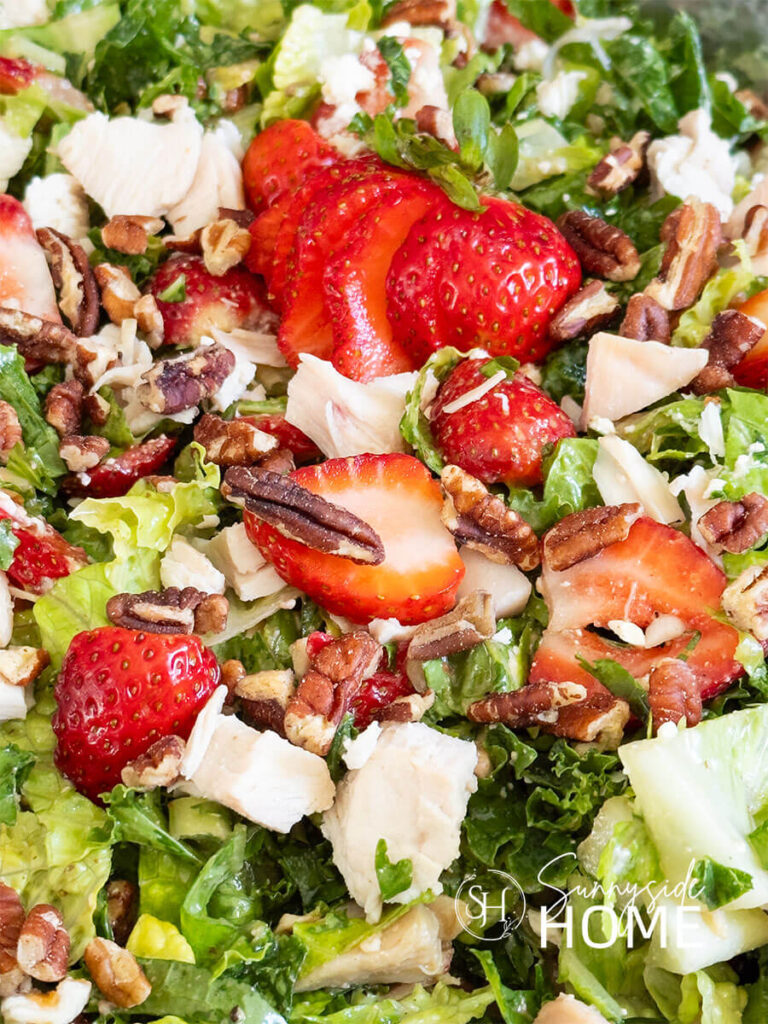 Strawberry chicken salad, this salad features a mix of greens, savory chicken, sweet fresh strawberries, green onion, crunchy pecans, creamy feta cheese and a sweet and tangy lime maple balsamic vinaigrette. A healthy summer salad.