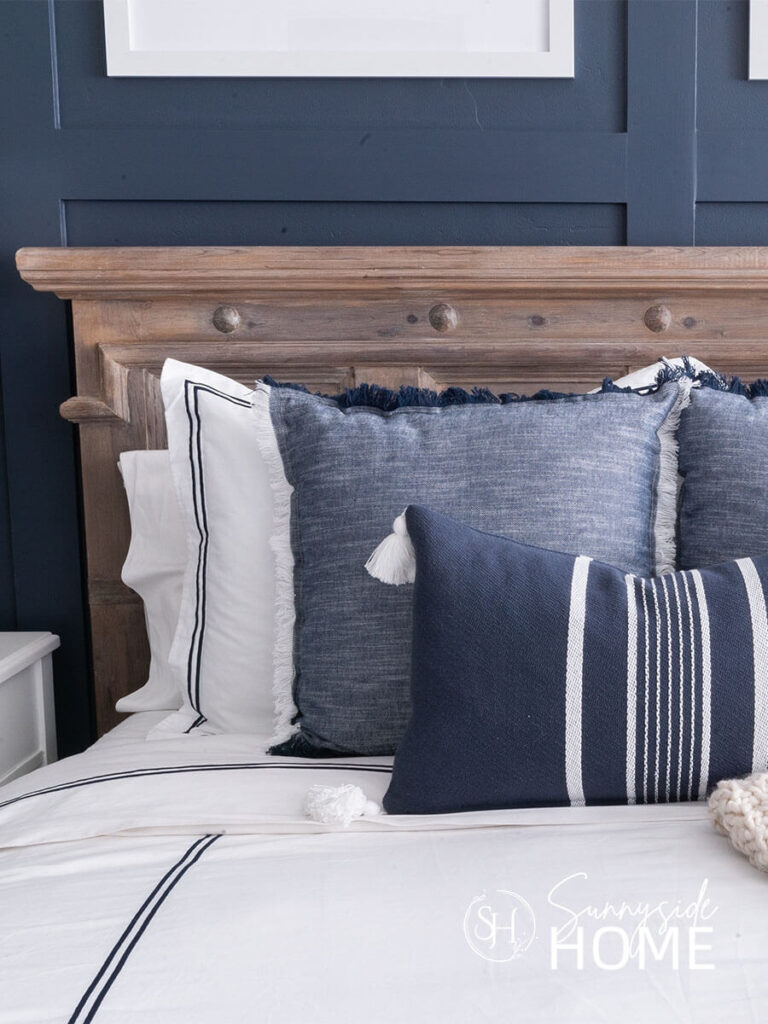 Pretty blue and white textiles dress the bed. White duvet and shames with a pretty blue trim, the bed is also styled with more blue and white pillows.
