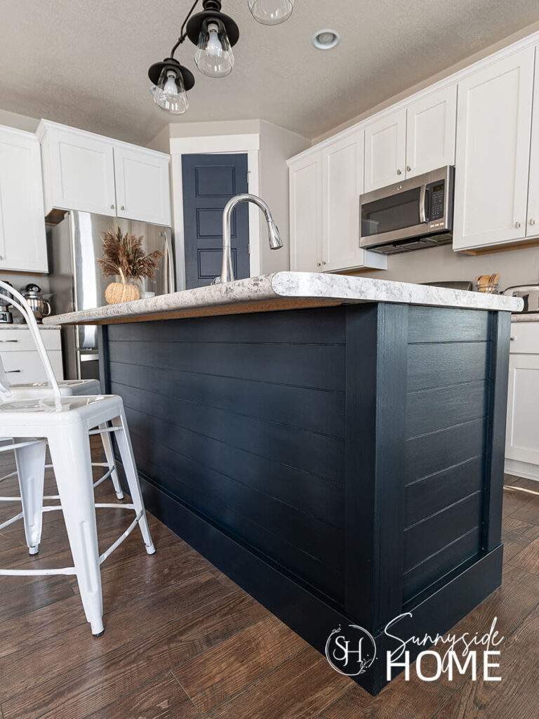 Decorate with blue and white in the kitchen with a blue painted island and white shaker cabinets.