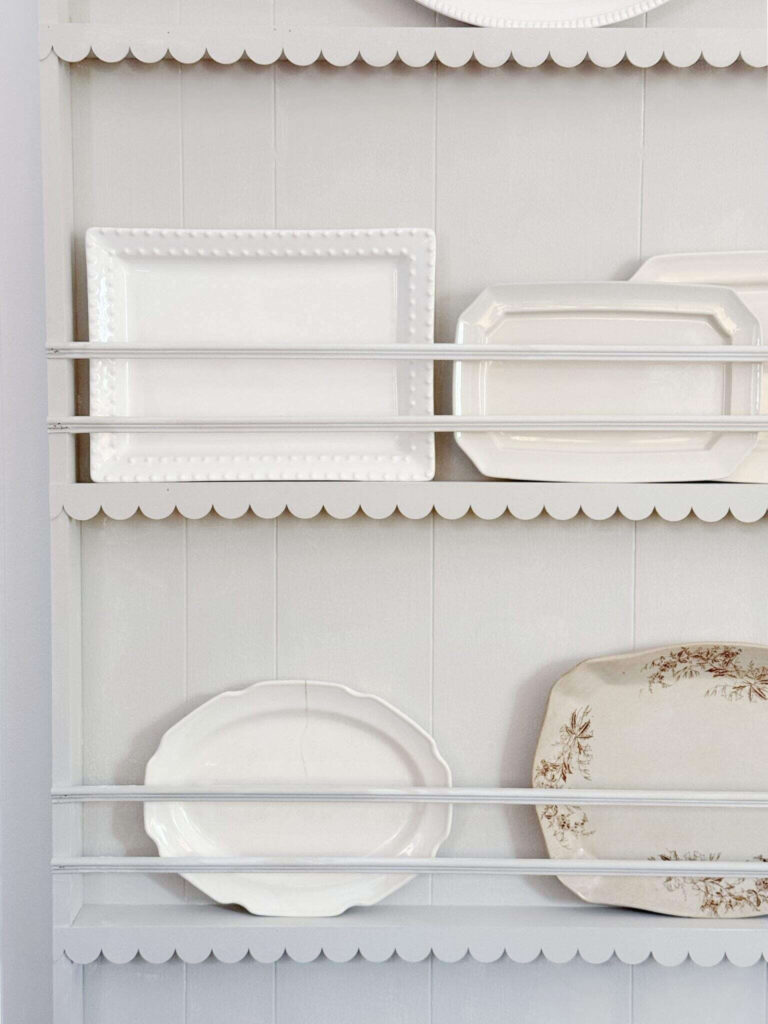 Scallop moulding is added to a wall mounted plate rack, styled with assorted platters.