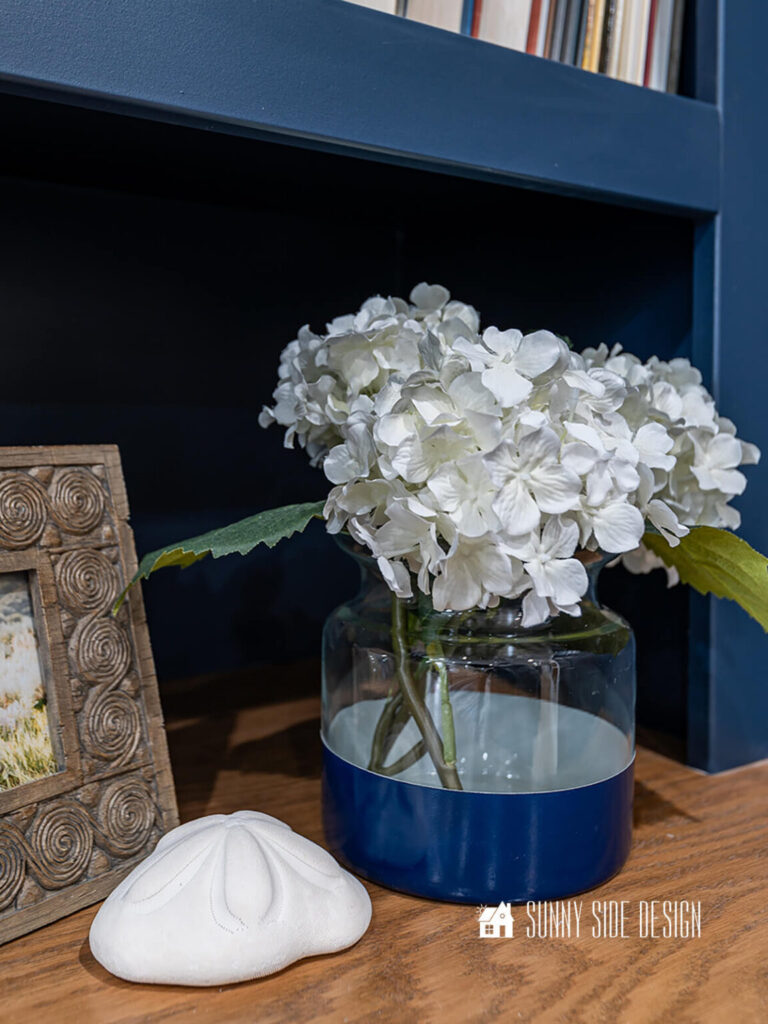 Blue color block glass vase with white hydrangeas.