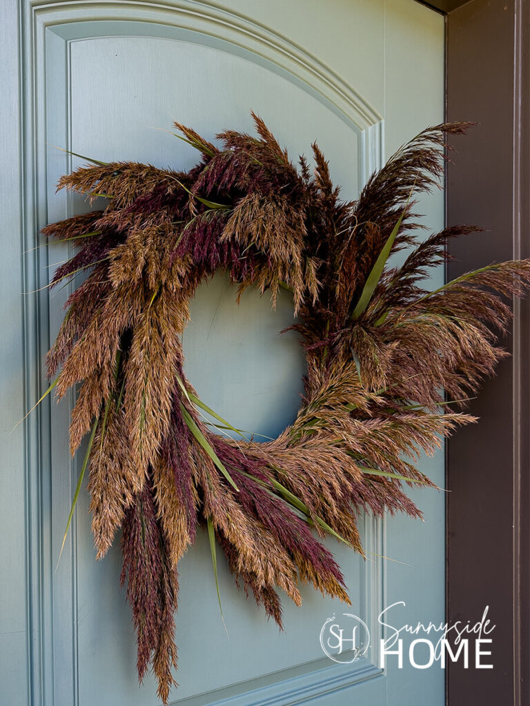 Beautiful Pampas Grass Wreath for Fall hung on a blue front door.