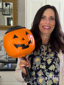 A woman hold the finished pumpkin solar light.