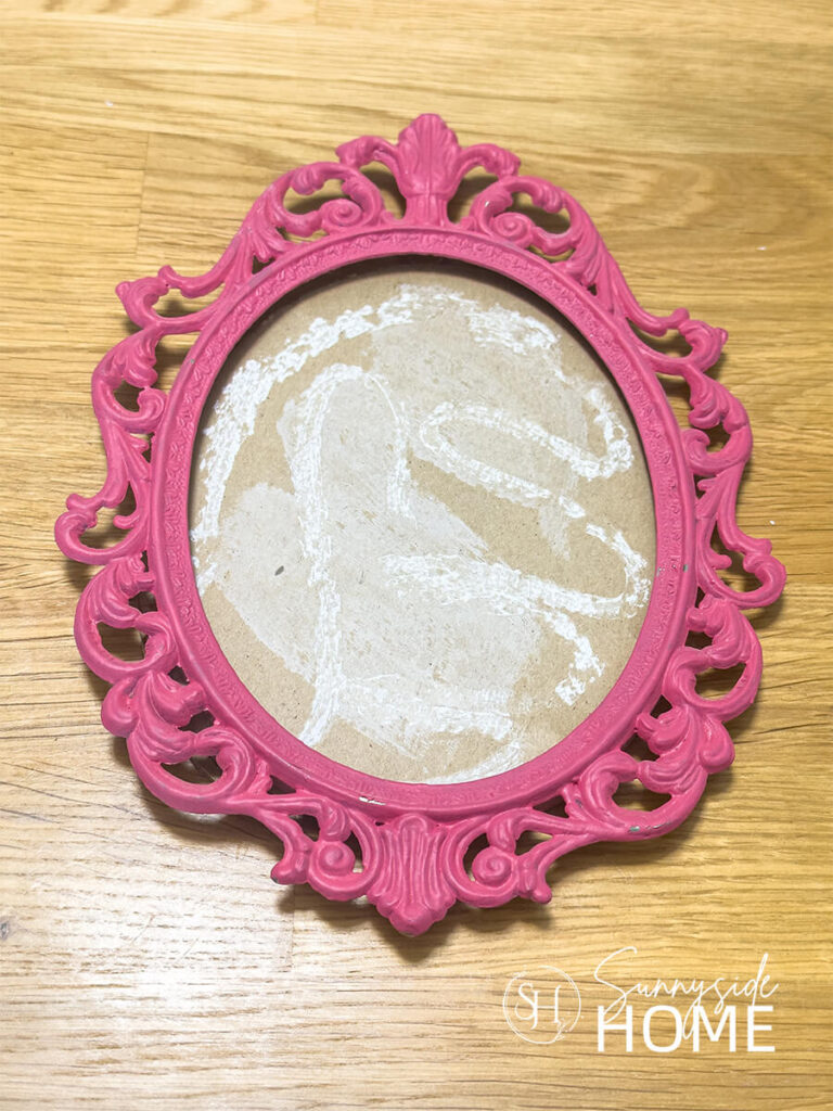 A vintage pink ornate picture frame.
