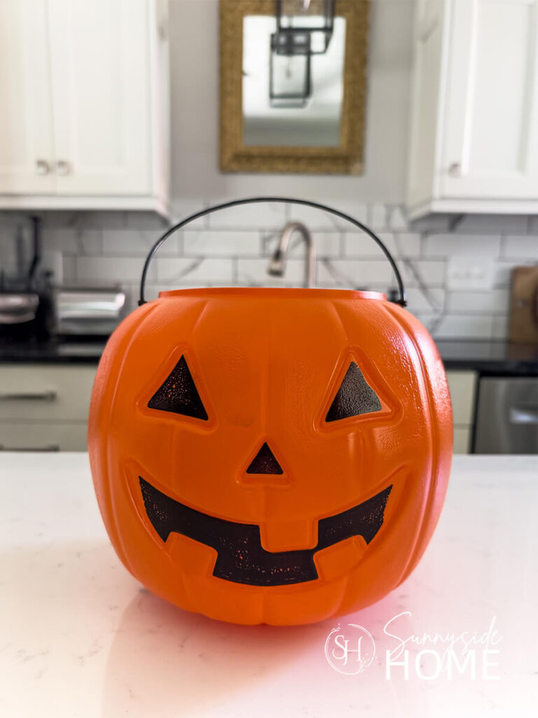 A orange jack-o-lantern pumpkin trick or treat bucket.