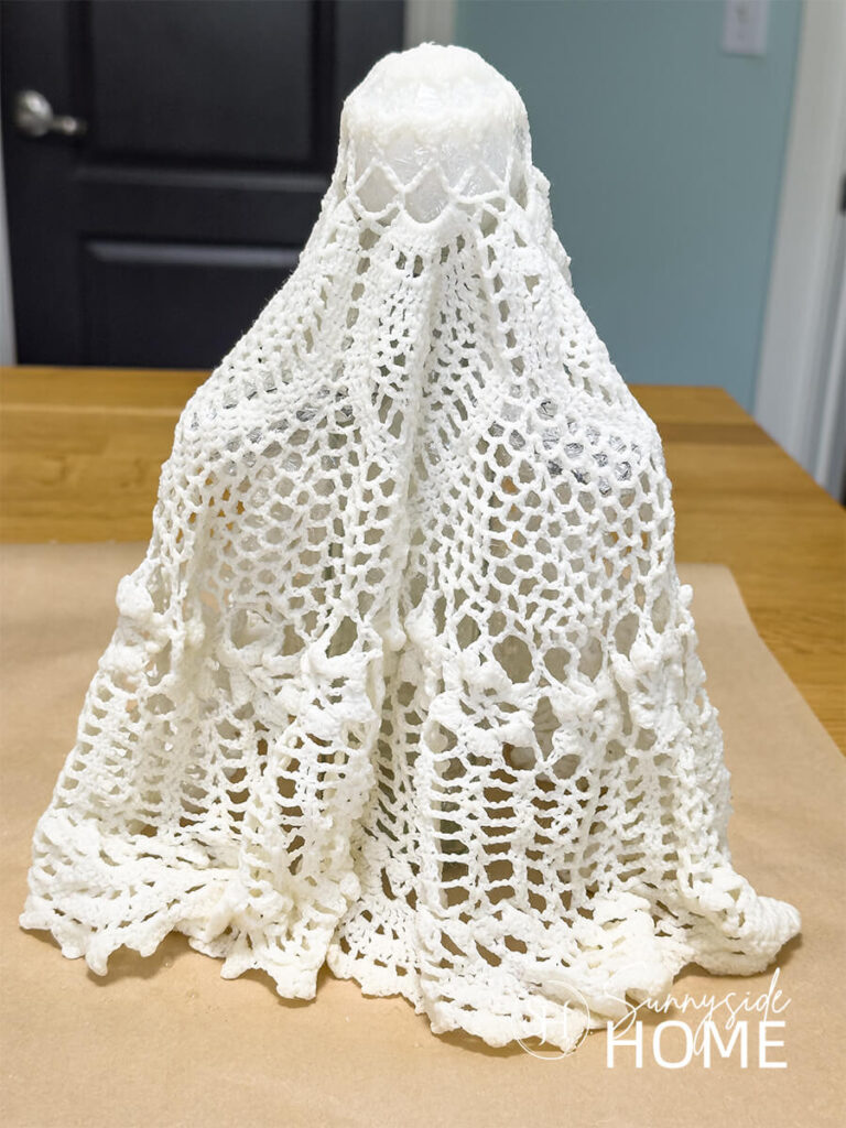 A ghost shape is formed with a vintage doily soaked in liquid fabric starch.