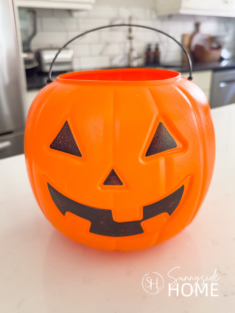 Orange plastic jack-o-lantern pumpkin trick or treat bucket.