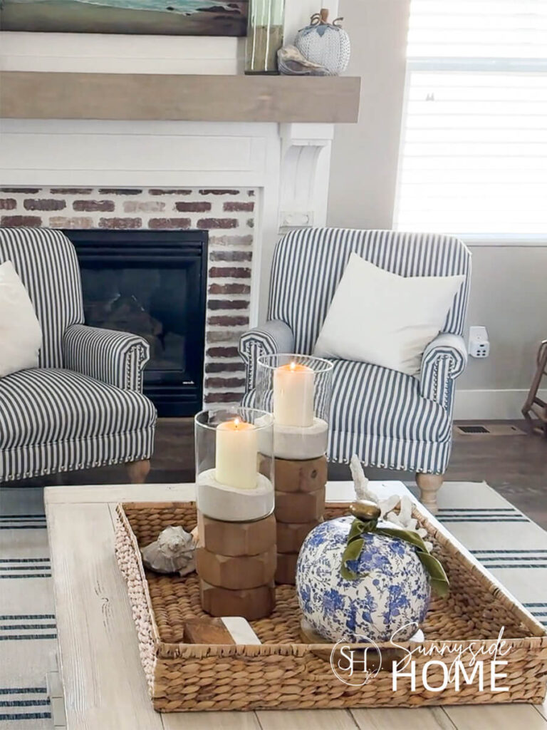 Styled blue and white chinoiserie decoupage pumpkins with pretty floral napkins, embellished with green velvet ribbon, styled in a basket with wood candleholders.