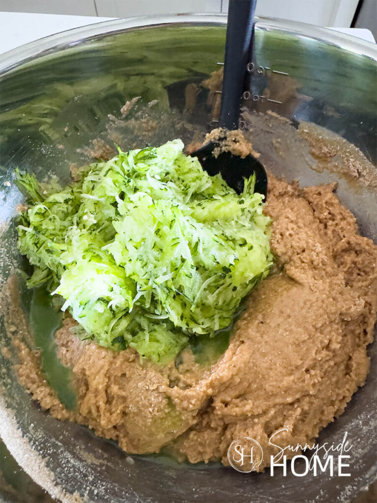 Mix in the shredded zucchini into the protein zucchini muffin batter.
