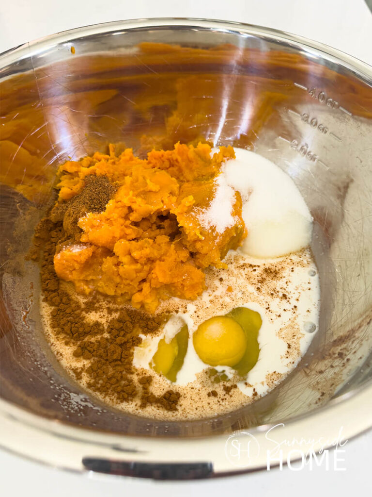 Ingredient for the sweet potato casserole in a stainless steel mixing bowl.