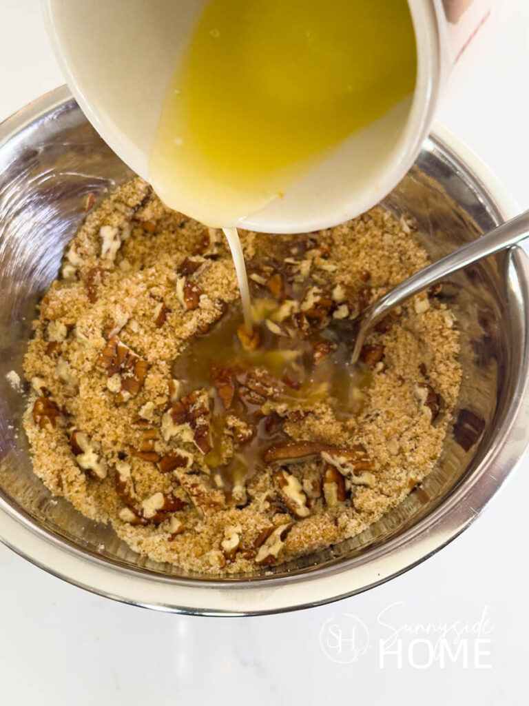 Butter is poured over the brown sugar and pecan mixture.