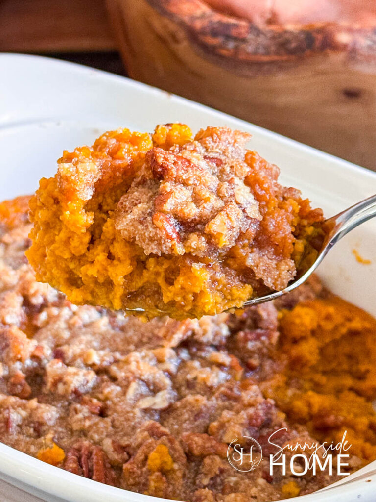 A spoonful of decadent sweet potato casserole from the dish.