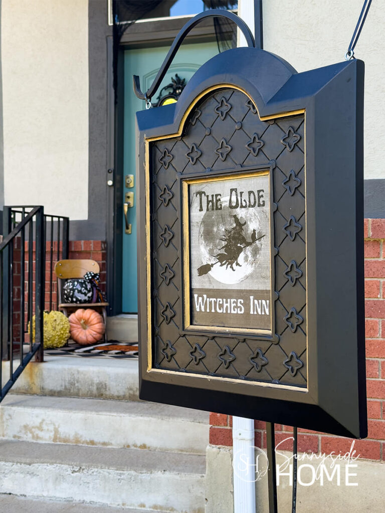 A thrifted store frame is reimaged with black paint and gold Rub N Buff with a Witch Inn Sign.
